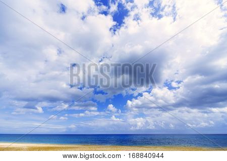 Beautiful sea paradise beach on a background of blue sky with clouds.