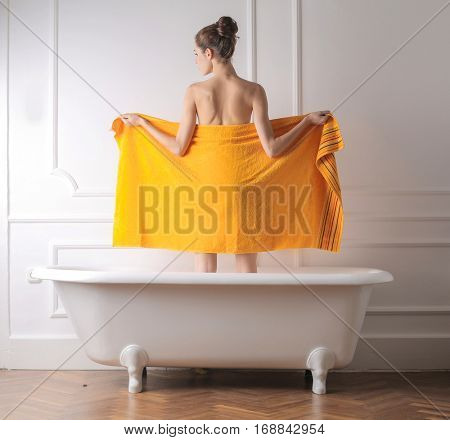 Girl showing her back covered wth a yellow towel
