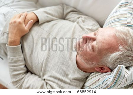 old age, rest, comfort and people concept - close up of senior man sleeping on sofa