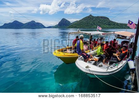 Semporna,Sabah-Sept 10,2016:Group of tourist arrived at Bohey Dulang jetty Semporna,Sabah with beautiful islands on  background.Bohey Dulang Island is one of the most popular & attraction islands in Tun Sakaran Marine Park.
