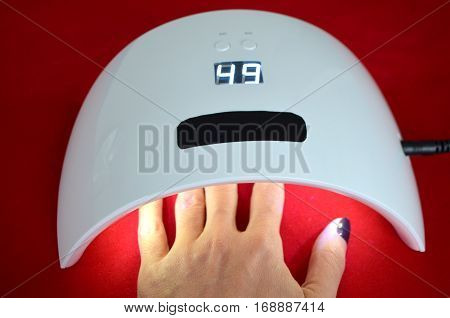 Nail gel salon. Beautiful woman hand and lamp UV  for nails UV with timer