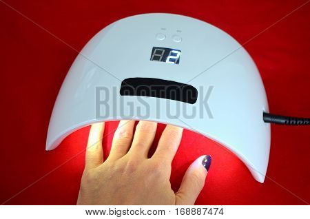 Nail gel salon. Beautiful woman hand and lamp UV  for nails UV with timer