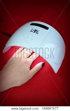 Nail gel salon. Beautiful woman hand and lamp UV  for nails UV with timer