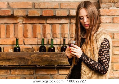 Woman Tasting Wine In Rural Cottage Interior