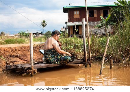 Inle Lake Myanmar - 2017 January 2 : A woman bathing and washing herself in a canal on the Inle Lake in central Myanmar
