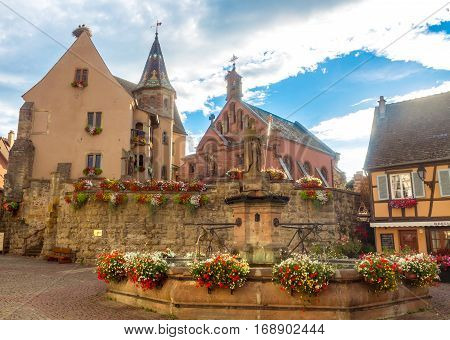 Beautiful view of square of Saint-Leon in the historic town Eguisheim, a popular tourist destination along the famous Alsace Wine Route, in beautiful evening light at sunset in summer, Alsace-Champagne-Ardenne-Lorraine, France