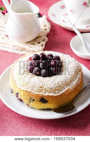Blackcurrant cake on pink background with tea, vertical