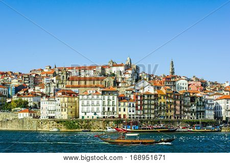 Porto Portugal old town cityscape on the Douro River with traditional Rabelo boats.