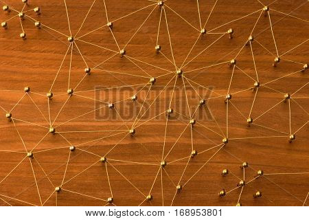 Linking entities. Large network. Network, networking, social media, internet communication abstract. Many small network connected to a larger network. Web of gold wires on rustic wood. 