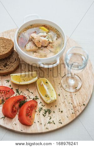 Russian traditional fish soup - ukha, served with bread lemon tomato and vodka