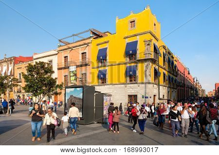 MEXICO CITY,MEXICO - DECEMBER 23,2016 : People and colorful buildings next to the Zocalo, at Mexico City Historic Center