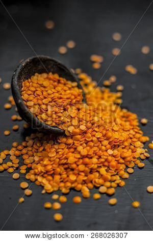Close Up Of Raw Masur Dal Or Masoor Lentils Or Pink Lentils In A Black Colored Clay Bowl On Wooden S