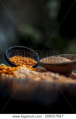 Close Up Of Raw Pink Lentils In A Clay Bowl On Wooden Surface With Its Powder.