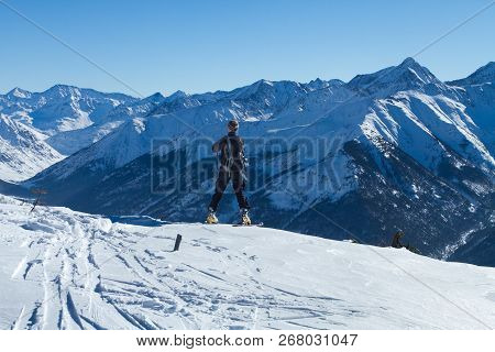 A Man Stands On Top Of A Mountain