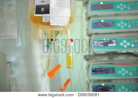Blood Plasma Bag Dripping To The Patient On The Background Og Medical Equipment.