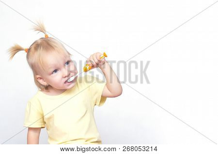 The Little Girl The Blonde With Pigtails On The Head Of The Caucasian Appearance Brushes Her Teeth A