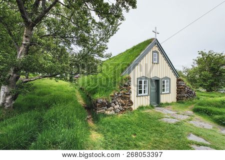 A Small Wooden Church And Cemetery Hofskirkja Hof, Skaftafell Iceland. Scenic Sunset Through Tree Cr