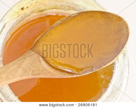 cucchiaio di legno con il miele sul vaso