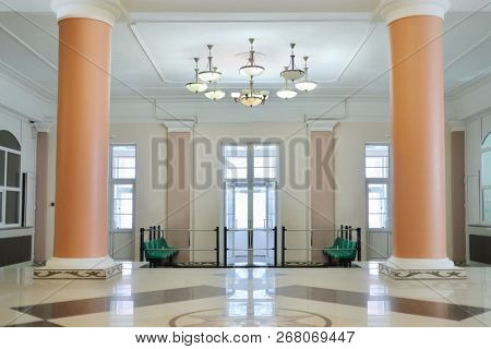 Empty hall with tall columns and big chandelier on the ceiling