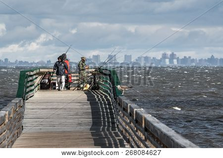 Middletown, New Jersey - November 3 - Fishermen On A Windy Autumn Day Fish Off Long Wooden Pier On N