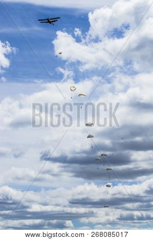 A Group Of Paratroopers Jumping From The Plane One After Another