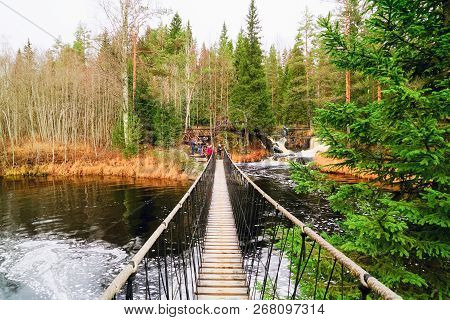 Suspended Pedestrian Bridge Over A Waterfall On The Tohmajoki River.