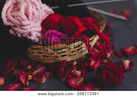 Knitting Yarn And A Ball Of Yarn In A Straw Basket. Dry Petals And Dried Flowers. Concept Of Home, W