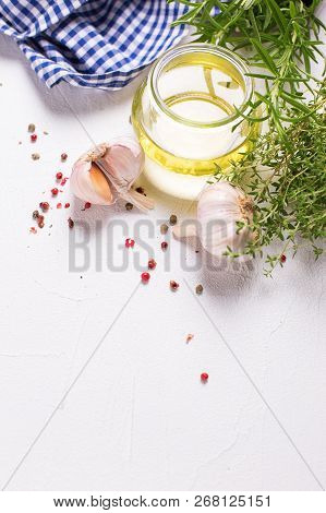 Bottle With Olive Oil With Herb And Spices On  White Textured Background. Top View. Selective Focus.
