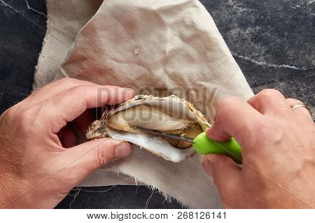 View Of Male Hands Shucking Fresh Oyster, View From Above