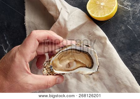 View Of Male Hands Shucking Fresh Oyster, View From Above