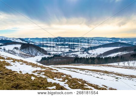 Winter Landscape On Wasserkuppe With Snow And Dramatic Sky In Rhoen Mountains, Germany