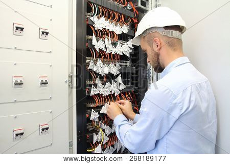 Technician In Communications Box Connecting Opto Fibers. Maintenance Of Communication Equipment. Eng