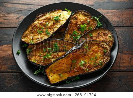 Healthy Vegeterain Oven Baked Aubergines, Eggplant With Parsley And Herbs In A Black Plate