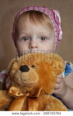 Happy One Year Old Girl Playing And Posing With A Yello Teddy Bear