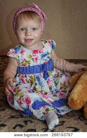 Happy One Year Old Girl Playing And Posing With A Yello Teddy Bear
