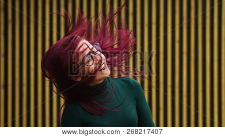 Cute Young Girl Dancing On Background Of Simple Geometric Pattern. Girl Has Eggplant Hair Flying In 