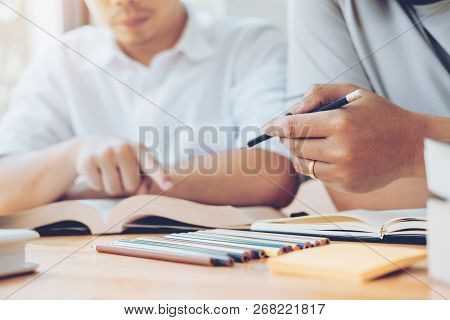 High School Or College Students Studying And Reading Together In Library