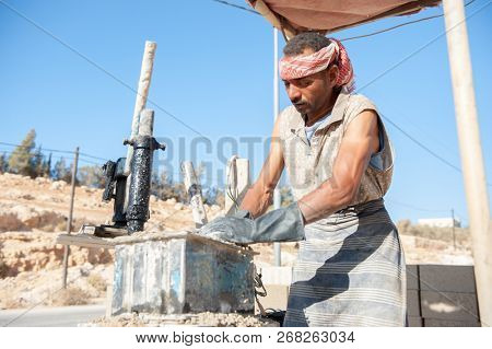 Man making brick from concrete mix.Zarqa-Jordan. 22/7/2013