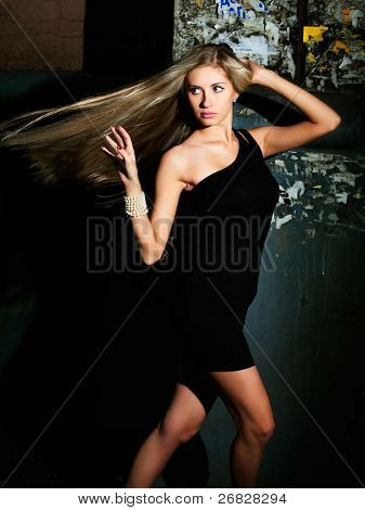 Portrét blondýna s rozcuchanými vlasy, v pozadí město