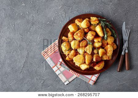 Crunchy Cornmeal Breaded Roast Potatoes With Spices And Rosemary Served On A Clay Dish With Napkin A