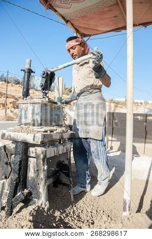  Man making brick from concrete mix.Zarqa-Jordan. 22/7/2013
