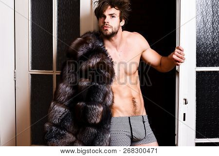 Guy Attractive Posing Fur Coat On Naked Body. Richness And Luxury Concept. Luxury Lifestyle And Well