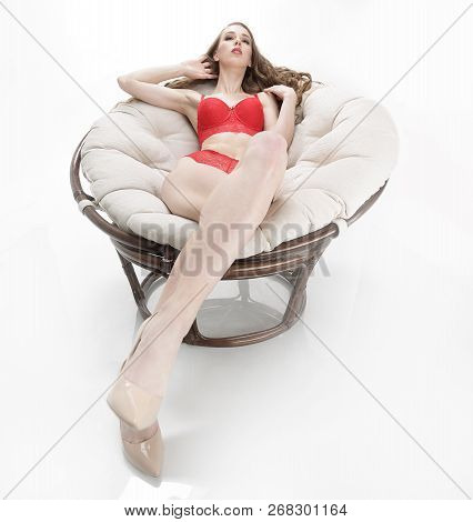 Beautiful Woman In Red Underwear Relaxing In A Round Chair Papasan .photo With Copy Space