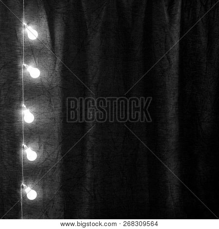 Garland Of Light Bulbs Hanging Verticaly In The Dark Room