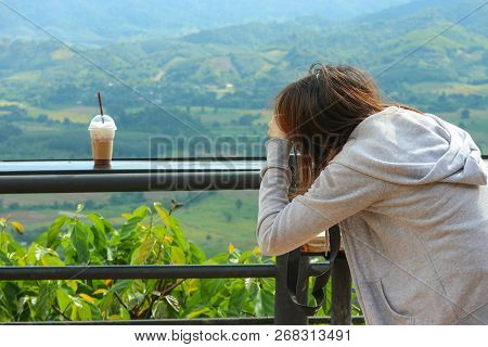 An Asian Taking A Photo Of Iced Coffee In Plastic Cup With Natural View Backgound.