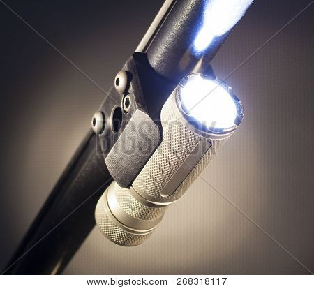 Flashlight Mounted An Running Under A Shotgun Barrel