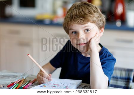 Happy Smiling Little Kid Boy At Home Making Homework At The Morning Before The School Starts. Little
