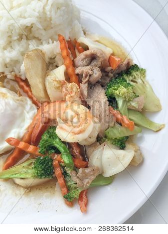 Mixed Vegetable Stir-fried With Shrimp, Pork And Chicken With Rice And Fried Egg In White Plate. Veg