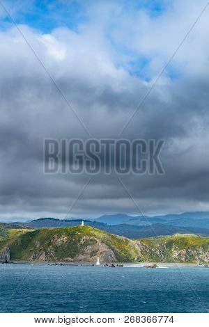 Pencarrow Head Two Lighthouses And Wellington Southern Coastline  From Ferry Under Dark Ominous Clou