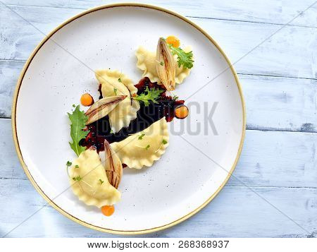 Goose Filled Dumplings With Carmelised Shallots On Black Sauce With Pinch Of 
Cress